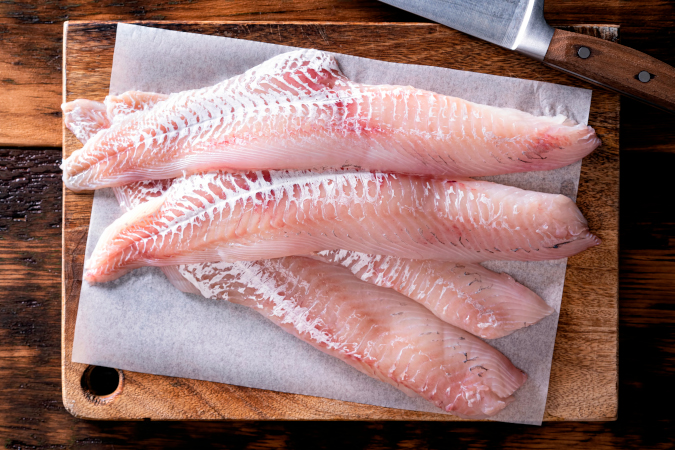 Raw skinned haddock fillets on a cutting board
